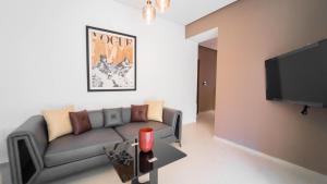 a living room with a couch and a flat screen tv at Aurora Piscine Chauffée à quelques pas de la mer in El Haouach