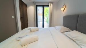 a large white bed with towels on top of it at Aurora Piscine Chauffée à quelques pas de la mer in El Haouach +4 photos