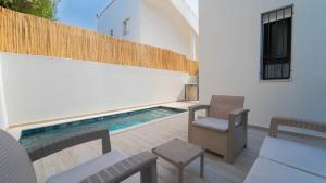 a patio with a swimming pool next to a building at Aurora Piscine Chauffée à quelques pas de la mer in El Haouach