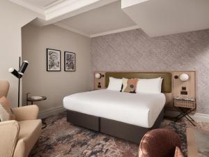 a bedroom with a large white bed and a couch at The Met Hotel Leeds - Newly Refurbished in Leeds