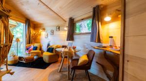 une chambre avec une table et des chaises dans une petite maison dans l'établissement Les cottages de Sarrant, à Sarrant