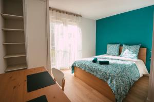 ein Schlafzimmer mit einem Bett mit einer blauen Wand in der Unterkunft Mon joli studio - Pessac in Pessac