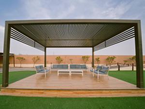 - un pavillon avec une table et des chaises sur une terrasse dans l'établissement Hideout Farmhouse - By Seven Elements, à Ras al Khaimah