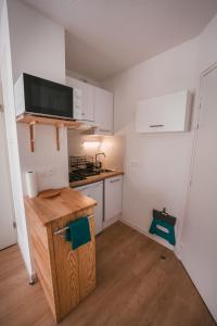 eine kleine Küche mit weißen Schränken und einer Arbeitsplatte in der Unterkunft Mon joli studio - Pessac in Pessac