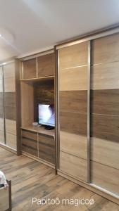 a room with wooden closet doors with a television at Appartement des Palmiers in Biskra
