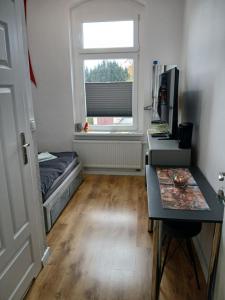 a small room with a desk and a window at Apartamenty Zakonne "Apartament Rycerza" in Malbork +3 photos