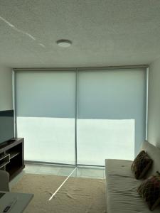 a living room with a couch and a large window at Altamira Surubi-i in Estancia Sarubi