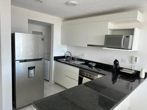 a kitchen with a stainless steel refrigerator and white cabinets at Altamira Surubi-i in Estancia Sarubi +5 photos