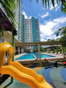 Un parque infantil con un tobogán amarillo y una piscina. en Dylan's Crib, en Bacolod
