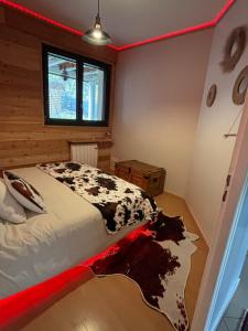 a bedroom with a bed with a black and white blanket at Appartement cosy entre lacs et montagnes in Guillestre