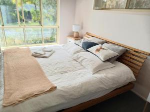 une chambre avec un grand lit blanc avec une fenêtre dans l'établissement 3mins walk to shopping centre city bus airport train station, à Brisbane