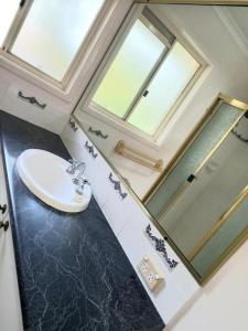 une salle de bain avec un lavabo et un miroir dans l'établissement 3mins walk to shopping centre city bus airport train station, à Brisbane