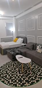 a living room with a couch and a coffee table at Lester Executive Studio Apartment 7 Minutes from United Nations & Embassies in Ruaka