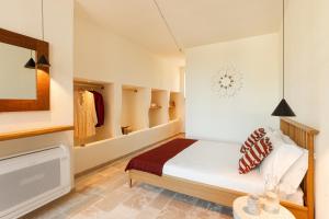 1 dormitorio con 1 cama y algunos estantes en Trulli D'Amore - Itria Valley Exclusive Trulli Villa, en Santa Lucia