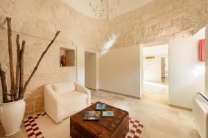 Una sala de estar con una silla y una mesa. en Trulli D'Amore - Itria Valley Exclusive Trulli Villa, en Santa Lucia