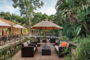 an outdoor patio with couches and an umbrella at Raydia Ventures Travel and Tours in Livingstone