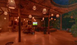 a living room with chandeliers and a table and a television at Kasa UhMay Tulum in Francisco Uh May