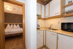 a small kitchen with a bed and a sink at Angelas Appart in Ehrwald