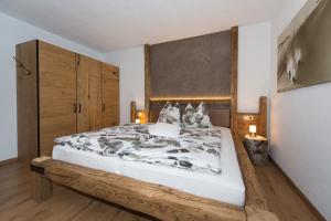 a bedroom with a large bed with a wooden headboard at Angelas Appart in Ehrwald