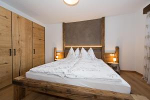 a bedroom with a large bed with white sheets and pillows at Angelas Appart in Ehrwald +4 photos