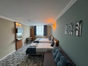 a hotel room with two beds and a couch at ERSOY EGE APART OTEL in Antalya