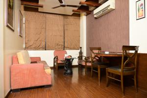 a living room with a table and chairs at Masara Biznotel in Chakan +18 photos
