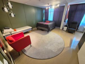 a room with a bed and a couch and a chair at NATO bunker with nice bed and appliancies in Mikkeli