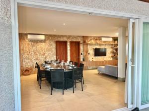 a dining room with a table and chairs at Uhane Grand Villa 7 Quartos, Piscina e Vista Mar in São Miguel do Gostoso
