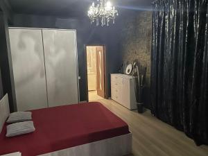 Un dormitorio con una cama y una lámpara de araña. en Magical Desire, en Bragadiru