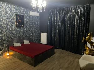 Un dormitorio con una cama roja en una habitación. en Magical Desire, en Bragadiru