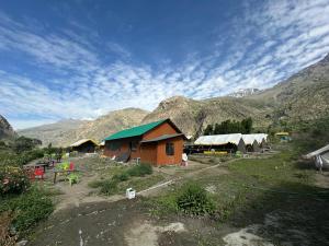 a group of huts with mountains in the background at River Rock Camps in Jispa +4 photos