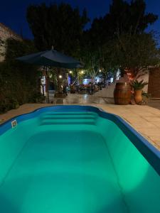 a blue swimming pool at night with an umbrella at El Viejo Molino in Chilecito +20 photos
