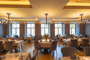 a dining room with tables and chairs and windows at Nunne Boutique Hotel in Tallinn