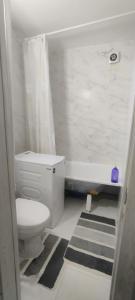 a bathroom with a toilet and a tub and a sink at Квартира посуточно Караганда in Karagandy