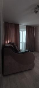 a bedroom with a large bed in front of a window at Квартира посуточно Караганда in Karagandy