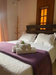 a bedroom with two towels on a bed at Pousada Luar da Serra Lumiar in Nova Friburgo