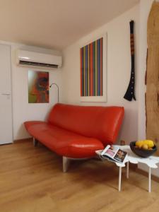 a living room with a red couch and a table at Maison-containers en Nord-Ardèche in Saint-Félicien