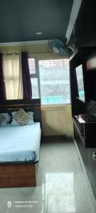 a small bedroom with a bed and a window at Hotel airport stay heavens in kolkata