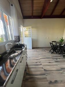a kitchen with a sink and a table with chairs at Chalés do vale Extrema Cinza in Extrema
