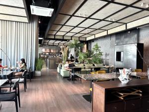 Un restaurante con mesas y gente sentada en las mesas. en Shō Hotel BreakX, en George Town