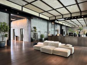 a room with four white beds on a wooden floor at Shō Hotel Penang in George Town
