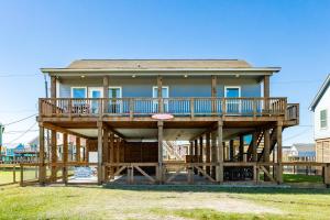 een groot houten huis met een groot terras bij Ultimate Gulf Views Hot Tub Pet Paradise in Hercules Offshore Heliport