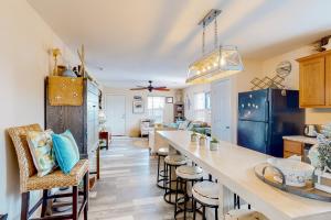 a kitchen with a long counter and stools at Crystal Beach 3BR Comfortable Home w/ Patio, Short Drive to Beach in Crystal Beach
