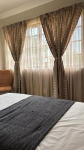 une chambre avec un lit et une fenêtre avec des rideaux dans l'établissement The N1 Farm Place, à Pretoria