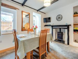 a dining room with a table and a fireplace at Stanley Cottage in Windermere +17 photos