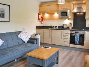 a living room with a couch and a kitchen at Solara Breeze in Reighton