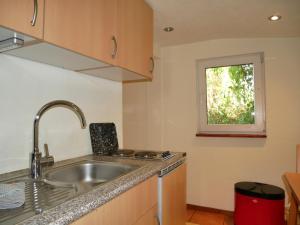 une cuisine avec un évier et une fenêtre dans l'établissement kleiner Holzbungalow Grundmann mit Naturgarten, à Wilhelmsfelde