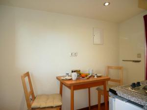 - une petite cuisine avec une petite table et des chaises dans l'établissement kleiner Holzbungalow Grundmann mit Naturgarten, à Wilhelmsfelde