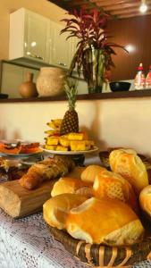 a table topped with lots of different types of bread at Pousada Luar da Serra Lumiar in Nova Friburgo +26 photos