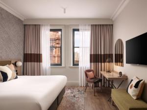 a hotel room with a bed and a desk at The Met Hotel Leeds - Newly Refurbished in Leeds